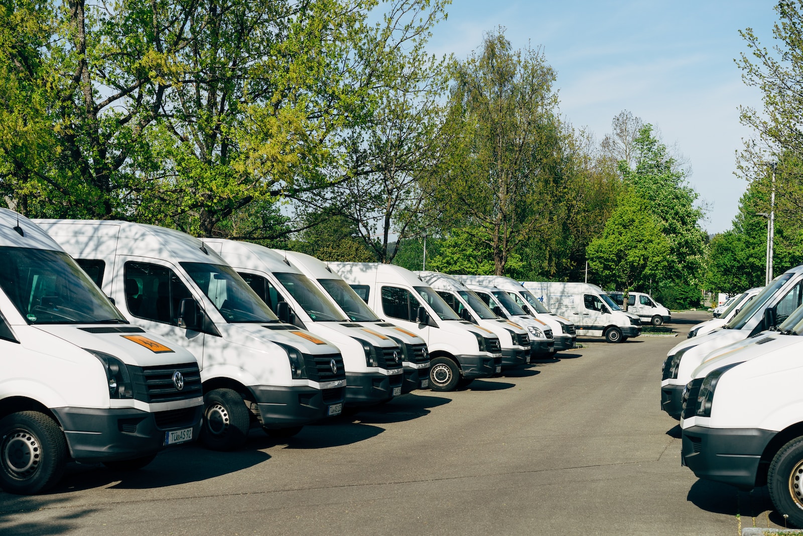 white commercial vans parked in a parking lot